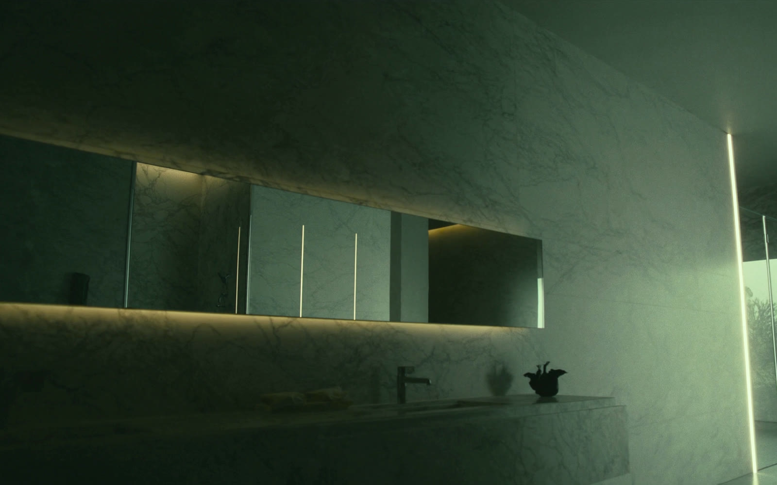 Espelho de grande formato com iluminação embutida em um lavabo revestido em pedra.